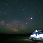 Límite del universo. Una casa de campaña y un cielo lleno de estrellas.