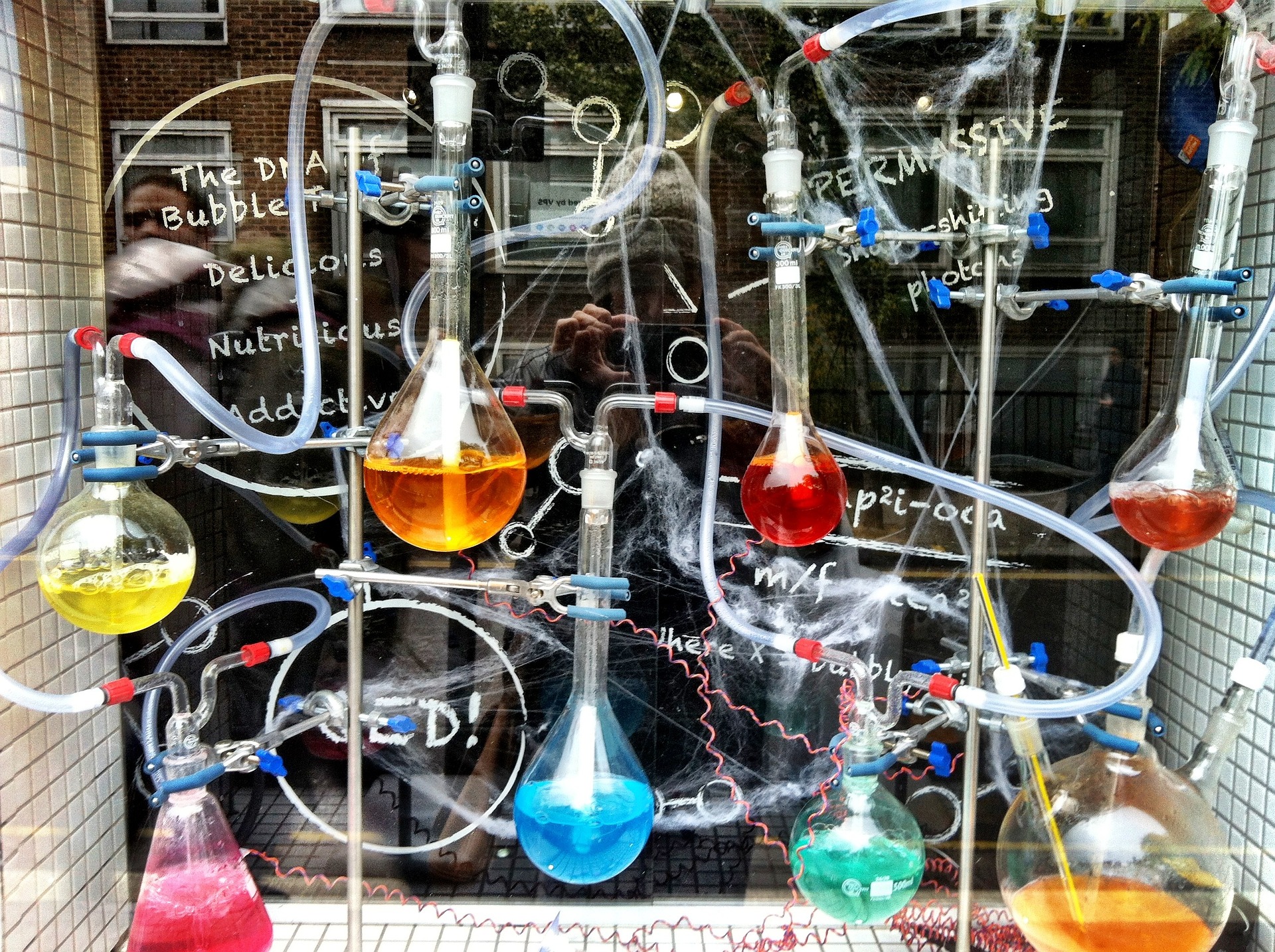 Experimento de química que muestra un proces de líquidos de colores brillantes en differente matraz y todos concetados por nas mangas.