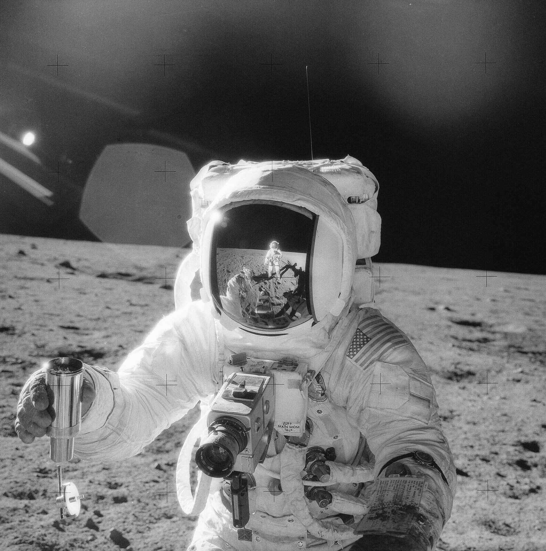The second manned lunar landing mission, Apollo 12 launched from launch pad 39-A at Kennedy Space Center in Florida on November 14, 1969 via a Saturn Five launch vehicle. The Saturn V vehicle was developed by the Marshall Space Flight Center (MSFC) under the direction of Dr. Wernher von Braun. Aboard Apollo 12 was a crew of three astronauts: Alan L. Bean, pilot of the Lunar Module (LM), Intrepid; Richard Gordon, pilot of the Command Module (CM), Yankee Clipper; and Spacecraft Commander Charles Conrad. The LM, Intrepid, landed astronauts Conrad and Bean on the lunar surface in what’s known as the Ocean of Storms while astronaut Richard Gordon piloted the CM, Yankee Clipper, in a parking orbit around the Moon. Their lunar soil activities included the deployment of the Apollo Lunar Surface Experiments Package (ALSEP), finding the unmanned Surveyor 3 that landed on the Moon on April 19, 1967, and collecting 75 pounds (34 kilograms) of rock samples. In this photograph, one of the astronauts on the Moon’s surface is holding a container of lunar soil. The other astronaut is seen reflected in his helmet. Apollo 12 safely returned to Earth on November 24, 1969.