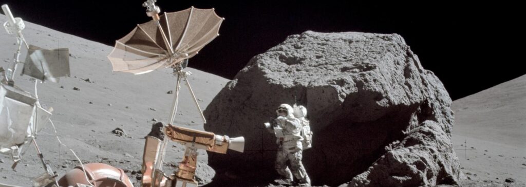 AS17-146-22294 (13 Dec. 1972) --- Scientist-astronaut Harrison H. Schmitt is photographed working beside a huge boulder at Station 6 (base of North Massif) during the third Apollo 17 extravehicular activity (EVA) at the Taurus-Littrow landing site. The front portion of the Lunar Roving Vehicle (LRV) is visible on the left. This picture was taken by astronaut Eugene A. Cernan, Apollo 17 commander. Schmitt is the lunar module pilot. While astronauts Cernan and Schmitt descended in the Lunar Module (LM) "Challenger" to explore the moon, astronaut Ronald E. Evans, command module pilot, remained with the Apollo 17 Command and Service Modules (CSM) in lunar orbit.
