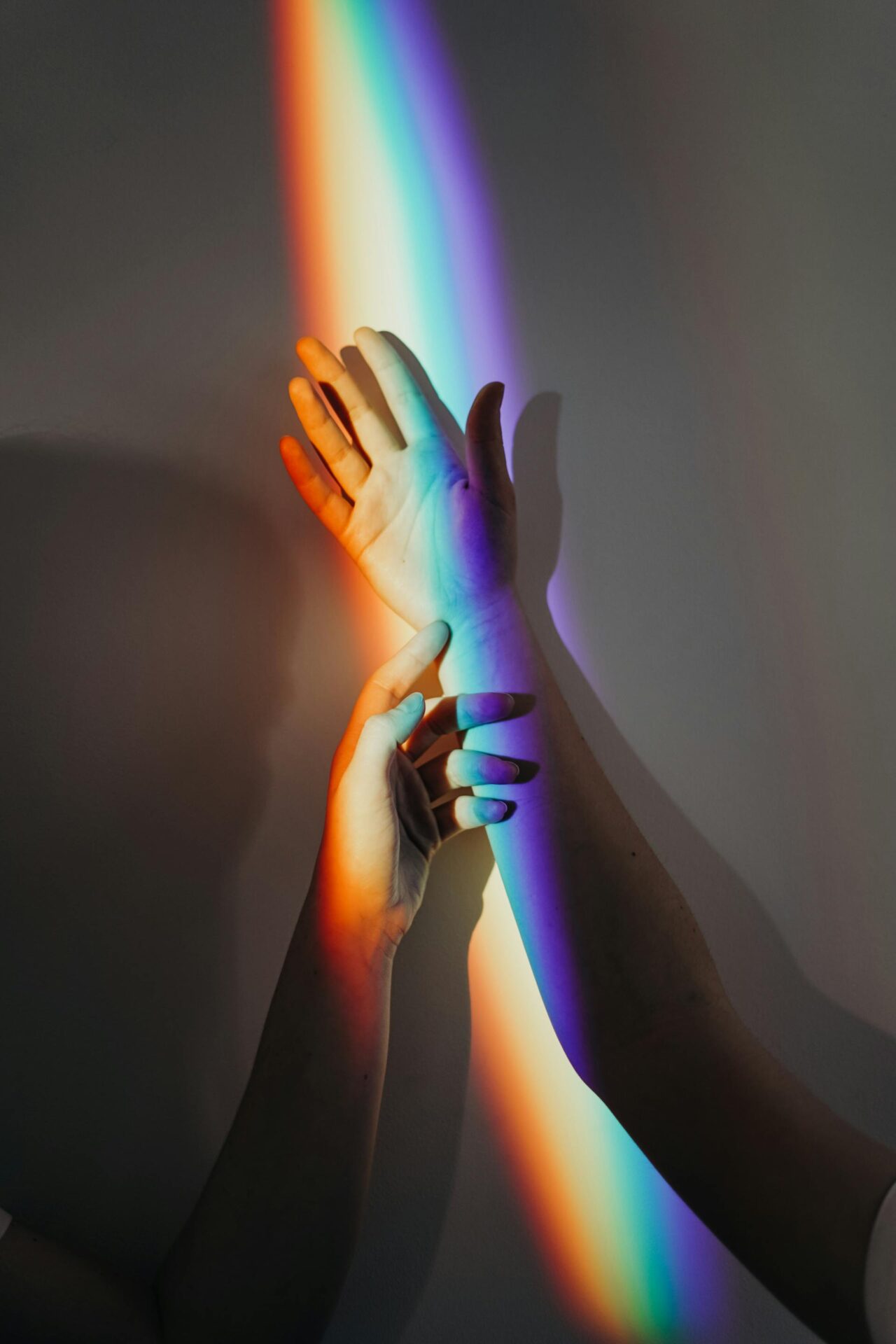 La perspectiva artística de la luz y el color en la imagen se ven dos manos y el espectro de color producido por un prisma