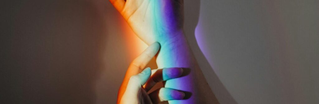 La perspectiva artística de la luz y el color en la imagen se ven dos manos y el espectro de color producido por un prisma