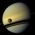 Saturno y su luna Titan orbitando alrededor del planeta. Imagen capturada por la misión Cassini de NASA.