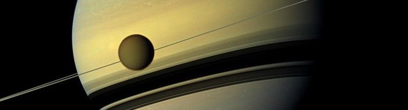 Saturno y su luna Titan orbitando alrededor del planeta. Imagen capturada por la misión Cassini de NASA